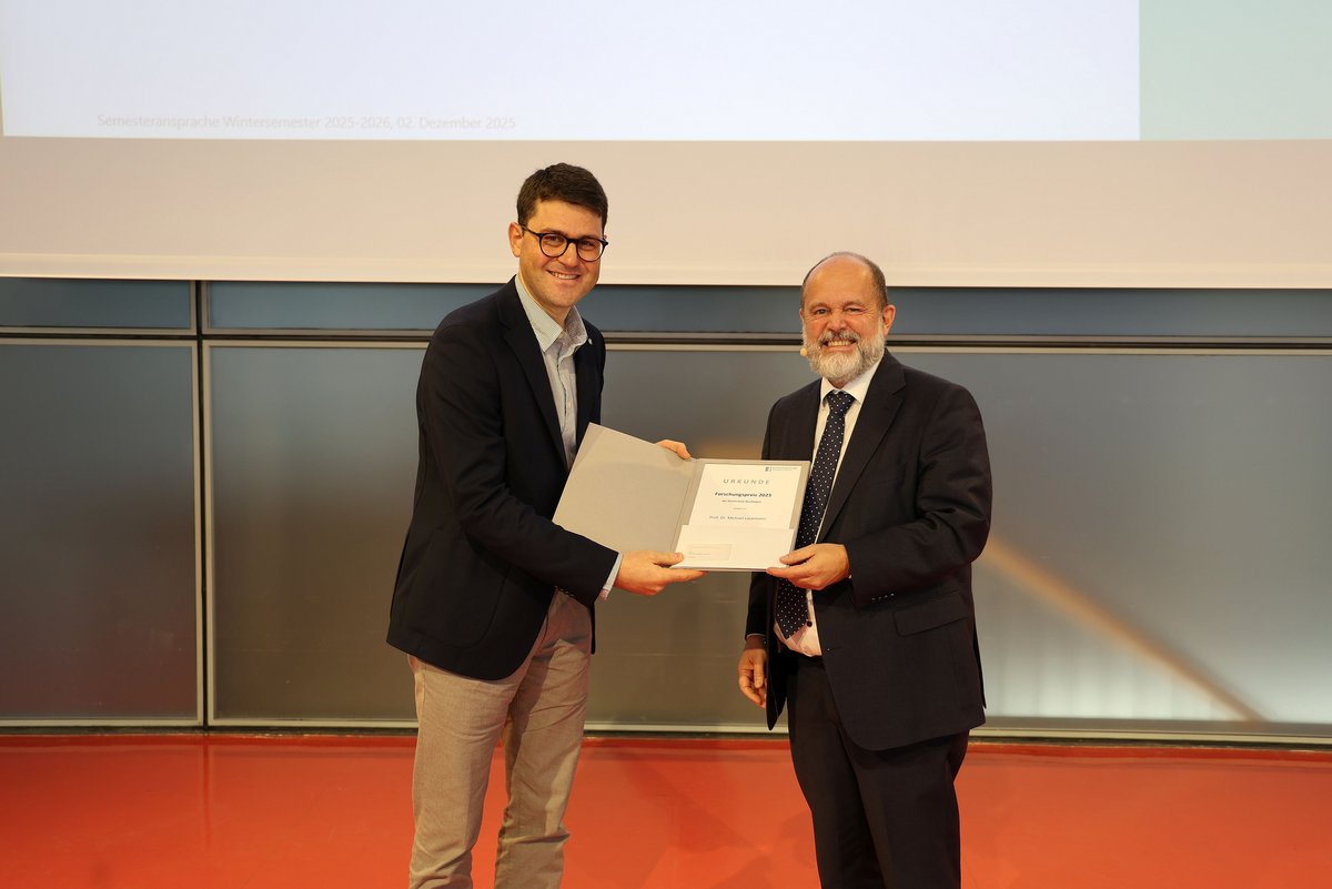 Der Vizepräsident für Forschung und Transfer, Prof. Dr. Stephan Seiter, überreicht den Forschungspreis der Hochschule an Prof. Dr.-Ing. Michael Lauxmann.